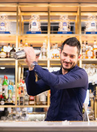 Bartender smiling and mixing a cocktail